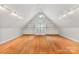 Bright bonus room with hardwood floors and built-in shelving, perfect for a home office, playroom, or media center at 6300 Latta Springs Cir, Huntersville, NC 28078