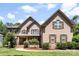 Charming brick home featuring a manicured lawn and inviting front porch at 6300 Latta Springs Cir, Huntersville, NC 28078