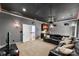 Living room with dark walls, ceiling fan, mini bar, and a comfortable looking black leather couch at 6300 Latta Springs Cir, Huntersville, NC 28078