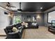 Comfortable black leather couch and home theater projector are featured in this moody living room at 6300 Latta Springs Cir, Huntersville, NC 28078