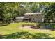 Expansive backyard features a lit fire pit and a charming outdoor seating area for entertaining and relaxation at 7015 Lavern St, Charlotte, NC 28215