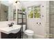 Well-lit bathroom featuring a modern vanity, marble style tile, and a sleek sink at 7015 Lavern St, Charlotte, NC 28215