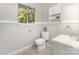 Bathroom with a patterned floor, sink, toilet, window, and a built-in cabinet at 7015 Lavern St, Charlotte, NC 28215