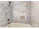 A beautifully tiled bathroom with shower and bathtub, featuring a built-in niche at 7015 Lavern St, Charlotte, NC 28215
