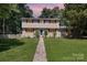Charming two-story home with a well-maintained lawn and pathway leading to a welcoming front entrance at sunset at 7015 Lavern St, Charlotte, NC 28215