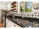 Modern kitchen with dark countertops, stainless steel appliances, and white cabinetry with open shelving at 7015 Lavern St, Charlotte, NC 28215