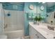 Bright, clean bathroom with teal walls, vanity, and tub with shower at 8619 New Oak Ln, Huntersville, NC 28078