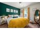 Charming bedroom with a plush bed, emerald accent wall, and decorative floral art at 8619 New Oak Ln, Huntersville, NC 28078