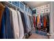 Organized walk-in closet featuring ample storage space with shelves, rods, and blue storage boxes at 8619 New Oak Ln, Huntersville, NC 28078