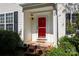 Close-up of a bright red front door with brick steps and manicured landscaping at 8619 New Oak Ln, Huntersville, NC 28078