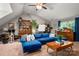 Spacious living room featuring a plush blue sectional sofa, wooden accents, and vaulted ceilings at 8619 New Oak Ln, Huntersville, NC 28078