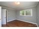 Bedroom featuring two windows with white trim, grey walls, and a door at 923 Yuma St, Charlotte, NC 28213
