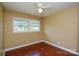 A bedroom with hardwood floors, neutral paint, and a window overlooking the front yard at 923 Yuma St, Charlotte, NC 28213