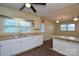 Bright kitchen featuring white cabinetry, tile backsplash, laminate countertops, and double sink at 923 Yuma St, Charlotte, NC 28213