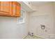 A laundry room with wooden cabinets and a window for natural light at 923 Yuma St, Charlotte, NC 28213
