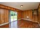 Living room includes wood paneled walls, wood floors and access to outside at 923 Yuma St, Charlotte, NC 28213