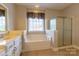 Elegant bathroom featuring a soaking tub, glass shower, and double sink vanity, creating a spa-like retreat at 1009 Brookline Dr, Huntersville, NC 28078