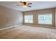 A bright bedroom featuring carpeted floors, a ceiling fan and two large windows for natural light at 1009 Brookline Dr, Huntersville, NC 28078