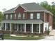 Beautiful two-story brick home with a covered front porch and well-maintained landscaping at 1009 Brookline Dr, Huntersville, NC 28078