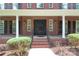 Stately brick home with a grand front porch and an elegant wrought-iron front door at 1009 Brookline Dr, Huntersville, NC 28078