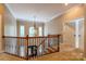 Second floor hallway features wood railing, wrought iron spindles, chandelier, and an open view of the foyer below at 1009 Brookline Dr, Huntersville, NC 28078