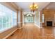 Open-concept living room featuring hardwood flooring, a fireplace, and large windows overlooking the backyard at 1009 Brookline Dr, Huntersville, NC 28078