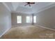 Spacious main bedroom featuring a ceiling fan, tray ceiling, and multiple windows for ample natural light at 1009 Brookline Dr, Huntersville, NC 28078