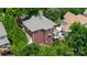 View of brick house with gabled roof and sunroom surrounded by lush landscaping at 1009 Brookline Dr, Huntersville, NC 28078