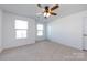 Inviting bedroom with neutral carpet, trim, two windows for natural light, and a ceiling fan at 10112 Andres Duany Dr, Huntersville, NC 28078