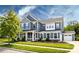Charming two-story home with blue siding, well-manicured lawn, and attached two car garage at 10112 Andres Duany Dr, Huntersville, NC 28078