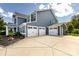 This home features a three-car garage, well-manicured flower beds, and a covered porch at 10112 Andres Duany Dr, Huntersville, NC 28078