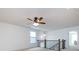 Spacious loft area with neutral carpet, a modern ceiling fan, and staircase access to other floors at 10112 Andres Duany Dr, Huntersville, NC 28078