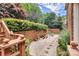 Backyard with chairs, brick walls, gravel, and lush foliage provides a relaxing retreat at 103 Samuel Guilford Ct, Charlotte, NC 28270