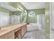 This spacious bathroom features double sinks, arched windows, soaking tub, and a separate shower at 103 Samuel Guilford Ct, Charlotte, NC 28270