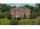 Elegant brick two-story home with arched windows and manicured landscaping on a lush, green lawn at 103 Samuel Guilford Ct, Charlotte, NC 28270