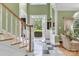Light filled foyer featuring black and white tile flooring, staircase, and open doorway at 103 Samuel Guilford Ct, Charlotte, NC 28270