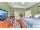 Bright main bedroom features a tray ceiling, wood floors, and an adjacent ensuite bath with a soaking tub at 103 Samuel Guilford Ct, Charlotte, NC 28270