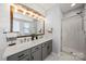 Stylish bathroom featuring a double vanity, a large mirror with accent lighting, and a glass-enclosed shower at 114 Nevis Ln, Mooresville, NC 28115