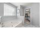 Serene bathroom featuring a soaking tub beneath a window, and an open entrance to a walk-in closet at 114 Nevis Ln, Mooresville, NC 28115
