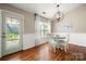 Bright dining area with wood floors, chair railing, modern lighting, and door access to outdoor area at 114 Nevis Ln, Mooresville, NC 28115