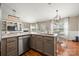 Open kitchen and living area showcasing a modern kitchen island with stainless steel dishwasher and sink, adjoining a dining area at 114 Nevis Ln, Mooresville, NC 28115