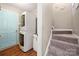 Practical laundry area adjacent to carpeted stairs, featuring a stacked washer/dryer unit and utility sink at 114 Nevis Ln, Mooresville, NC 28115