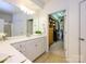 Bathroom featuring double sinks, white cabinets, and a walk-in closet at 11530 Costigan Ln, Charlotte, NC 28277