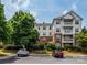 Exterior building shot with balconies, a well-manicured lawn, and a couple of vehicles parked out front at 11530 Costigan Ln, Charlotte, NC 28277