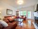 Bright living room featuring hardwood floors, fireplace, and comfortable leather sofas at 11530 Costigan Ln, Charlotte, NC 28277