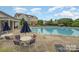 Inviting community pool with comfortable lounge chairs and umbrella-covered tables and lush greenery at 11530 Costigan Ln, Charlotte, NC 28277