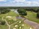 Breathtaking aerial view of the golf course, showcasing the pond and meticulously manicured lawns and sand bunkers at 11909 Cupworth Ct, Huntersville, NC 28078