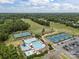 An aerial view showcases the community pool, tennis courts, and well-maintained golf course on a sunny day at 11909 Cupworth Ct, Huntersville, NC 28078