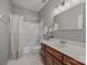Clean bathroom with a dark wood vanity, white countertop, and tub with shower at 11909 Cupworth Ct, Huntersville, NC 28078
