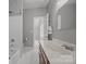 Bright bathroom featuring a tub with white tile surround and a vanity with matching floors at 11909 Cupworth Ct, Huntersville, NC 28078